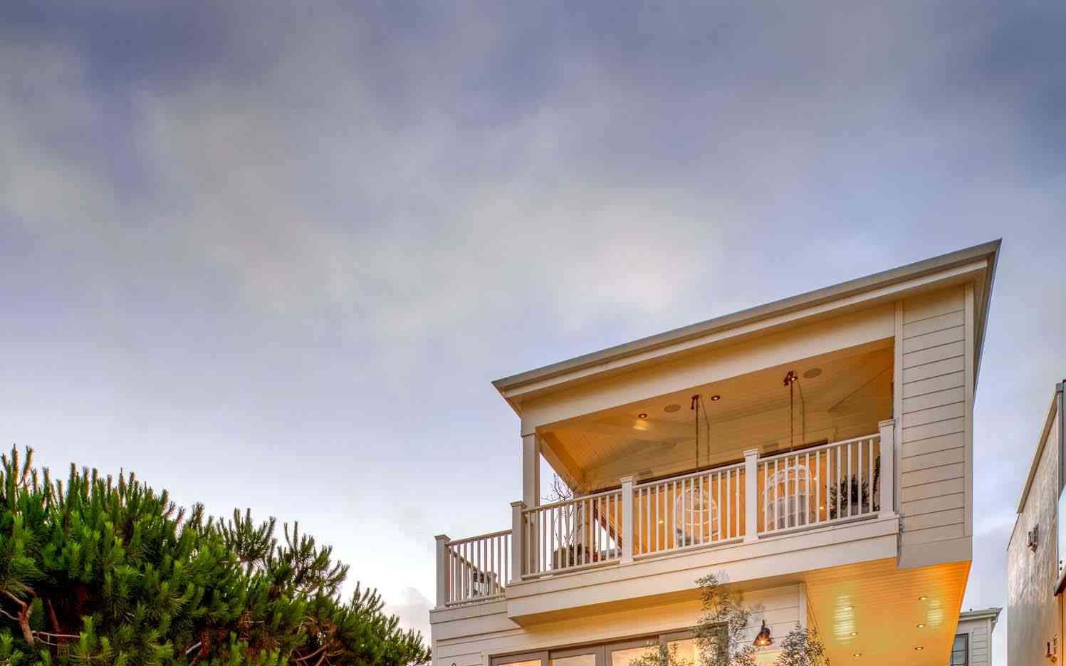 A contemporary home exterior with a crisp roofline and warm evening light